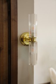 Rimini 35cm Mässing badrumslampa från Markslöjd - Rimini &auml;r en elegant v&auml;gglampa med stilrena detaljer i m&auml;ssingfinish och tv&aring; avl&aring;nga sk&auml;rmar i klart, ribbat glas.