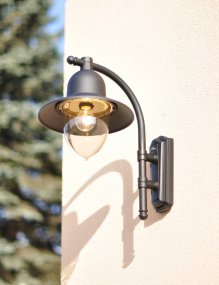 Como Svart utelampa från Norlys - Den svängda armen och vida skärmen kombineras med en klar glaskupa som sprider ett varmt och behagligt ljus, perfekt för att lysa upp entréer, verandor eller uteplatser.