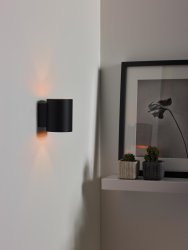 Xera 10cm Svart vägglampa från Lucide - Den dubbla ljusf&ouml;rdelningen i cylinderform skapar en unik effekt p&aring; tegel, betong eller m&aring;lade v&auml;ggar.