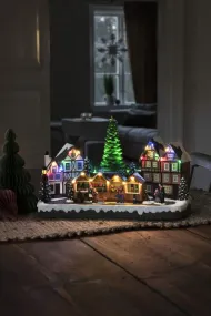 Mekanisk juldekoration julmarknad 24cm Flerfärgad från Konstsmide - Med 28 varmvita LED-lampor, sn&ouml;t&auml;ckta hus, f&auml;rgglada marknadsst&aring;nd och en st&aring;tlig julgran i centrum sprider den b&aring;de ljus och musik.
