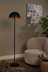 Siemon Svart golvlampa från Lucide - Ljusk&auml;llan sitter i mitten av den halvcirkelformade lampsk&auml;rmen, och ljuset reflekteras enkelt l&auml;ngs sk&auml;rmens v&auml;ggar, vilket skapar en varm och inbjudande atmosf&auml;r.