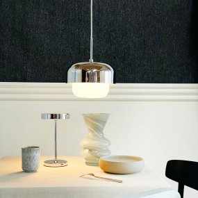 Haipot Ø23 Krom taklampa från Dyberg Larsen - Den stilrena designen kombinerar en &ouml;vre sk&auml;rm i metall med kromfinish och en underdel i vit glaskupa som sprider ett j&auml;mnt och behagligt ljus.