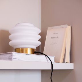 Diva 15cm Mässing bordslampa från Dyberg Larsen - Den elegant designade Diva bordslampan i m&auml;ssing ger en sofistikerad touch till varje hem och &auml;r ett konstverk som tillf&ouml;r liv och sk&ouml;nhet till rummet.