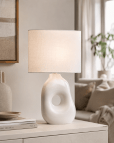 Pikazo 45cm Vit bordslampa från Lampan - Pikazo bordslampa har en unik keramisk fot med skulptural form och ett dekorativt genomg&aring;ende h&aring;l, kombinerad med en vit och oval linnesk&auml;rm.