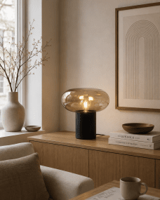 Alba 32cm Svart/amber bordslampa från Nordic Lighting - Den svarta metallfoten ger ett stabilt och elegant uttryck, medan den b&auml;rnstensf&auml;rgade glaskupan skapar ett mjukt och st&auml;mningsfullt ljus.