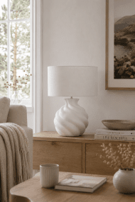 Vindel 52cm Vit bordslampa från Lampan - Lampfoten i keramik har en vit, strukturerad yta och en mjukt virvlande design som ger ett levande och skulpturalt uttryck.