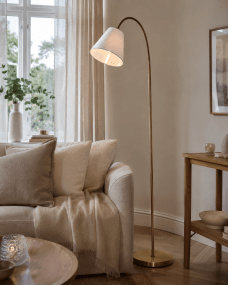 Uno Antikmässing golvlampa från Lampan - Den vita lampsk&auml;rmen i linne sprider ett mjukt och behagligt ljus och passar perfekt som l&auml;slampa vid soffan eller som st&auml;mningsbelysning i sovrummet.