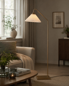 Nonna Antikmässing golvlampa från Lampan - Den vita, veckade sk&auml;rmen i linne sprider ett mjukt och behagligt ljus och passar perfekt som st&auml;mningsbelysning eller l&auml;slampa vid soffan och f&aring;t&ouml;ljen.