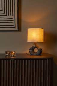 Tomeo 30cm Svart bordslampa från Lucide - Den ovala lampsk&auml;rmen i vit textil sprider ett mjukt och behagligt ljus och kompletterar fotens form p&aring; ett fint s&auml;tt.