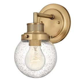 Poppy Ø13 Antik mässing badrumslampa från Elstead Lighting - Den klara glaskupolen med struktur reser sig vackert från den räfflade ramen i antikmässing, vilket skapar en sofistikerad siluett.