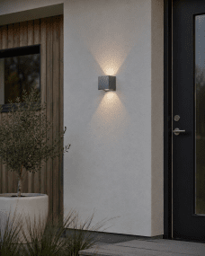 Alu Box 12cm Aluminium vägglampa från Lampan - Den unika designen skapar ett vackert upp- och nedljus som faller mjukt mot v&auml;ggen och ger rummet en behaglig och inbjudande atmosf&auml;r.