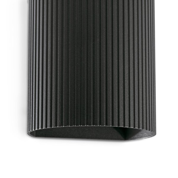 Sole 10cm Svart räfflad vägglampa från Faro Barcelona - Finns i tv&aring; storlekar och kan avge ljus i en eller tv&aring; riktningar &ndash; perfekt f&ouml;r hallar, trapphus och mindre utrymmen.