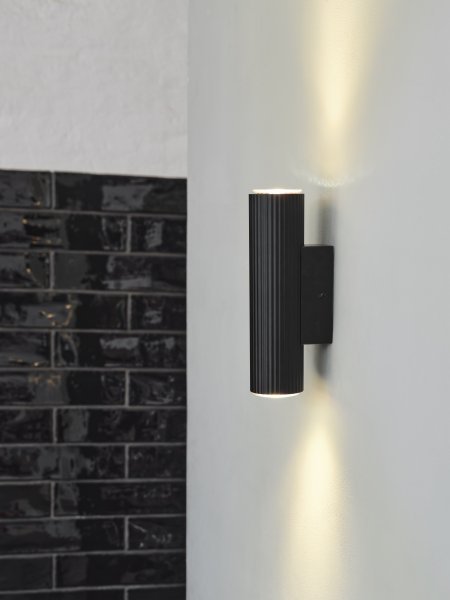 Drums 20cm Svart vägglampa från Ledvance - Den mattsvarta ribbade ytan i kombination med den fina ljusspridningen ner och upp p&aring; v&auml;ggen bidrar med en elegans till rummet.