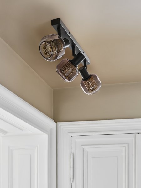 Firefly 3 Svart spotlight från Osram - De r&ouml;rliga spotlightsen med sk&auml;rmar av gr&aring;tonat glas i kombination med de guldiga detaljh&ouml;ljet som omfamnar ljusk&auml;llorna bidrar med en elegans till rummet.
