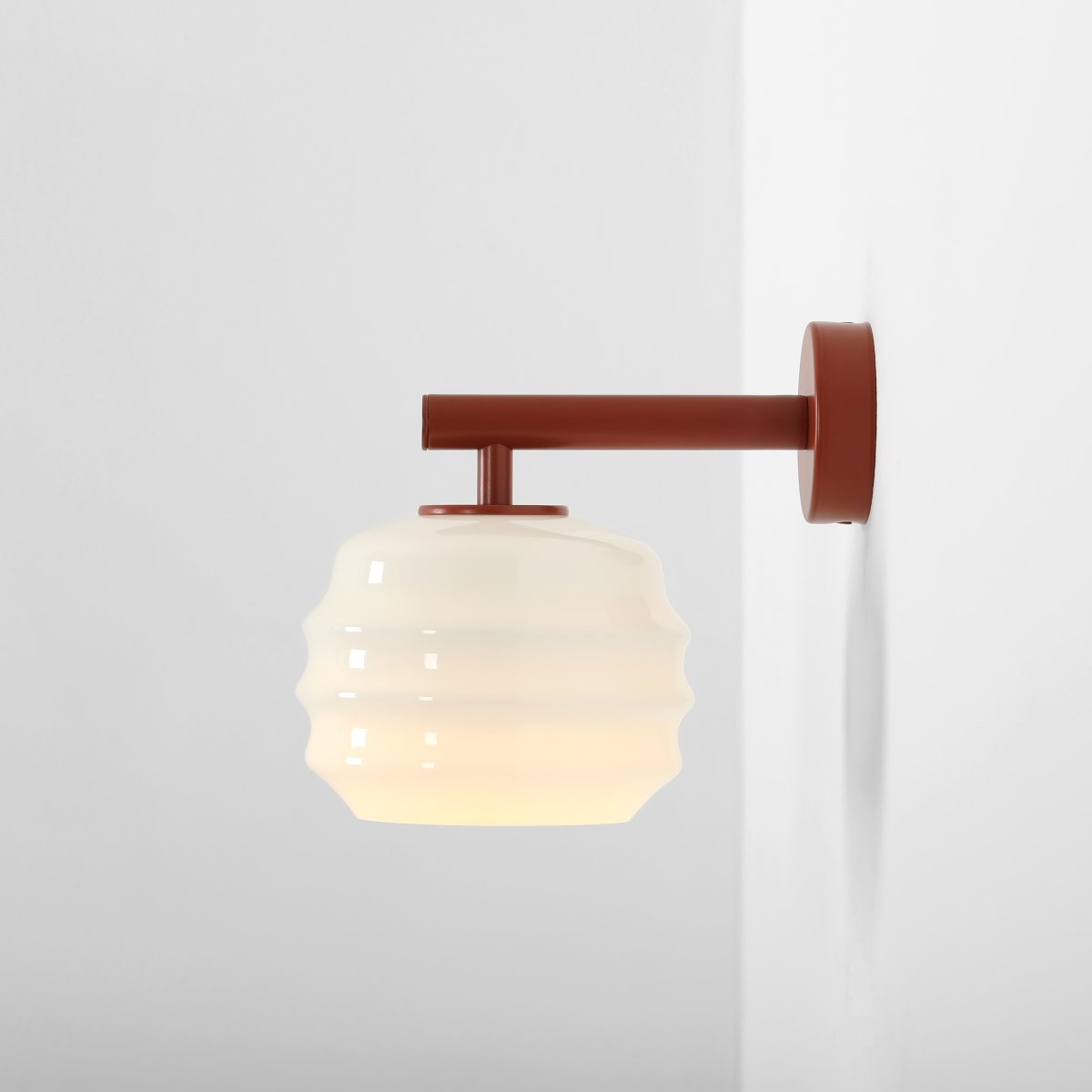 Puff 23cm Terrakotta vägglampa från Artera - Den dekorativa sk&auml;rmen i vitt opalglas har en v&aring;gig form som ger lampan ett lekfullt och elegant uttryck.