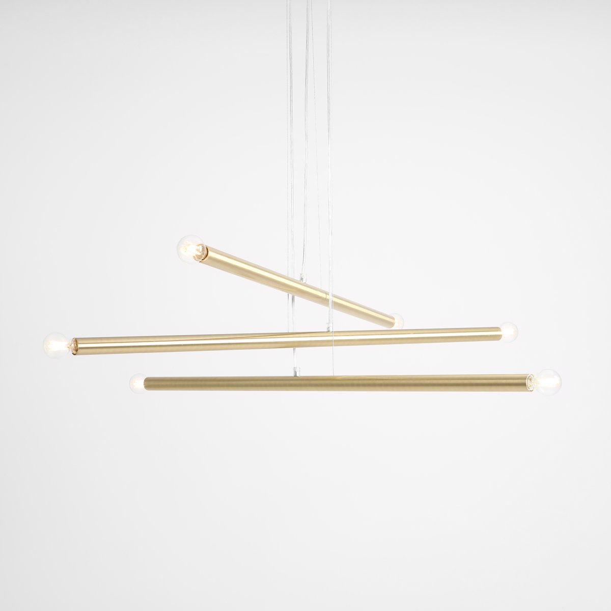 Tubo 6 100cm Mässing taklampa från Artera - Lampan best&aring;r av tre smala metallr&ouml;r i elegant m&auml;ssingfinish, placerade i olika h&ouml;jder och vinklar som skapar ett sp&auml;nnande och luftigt uttryck.