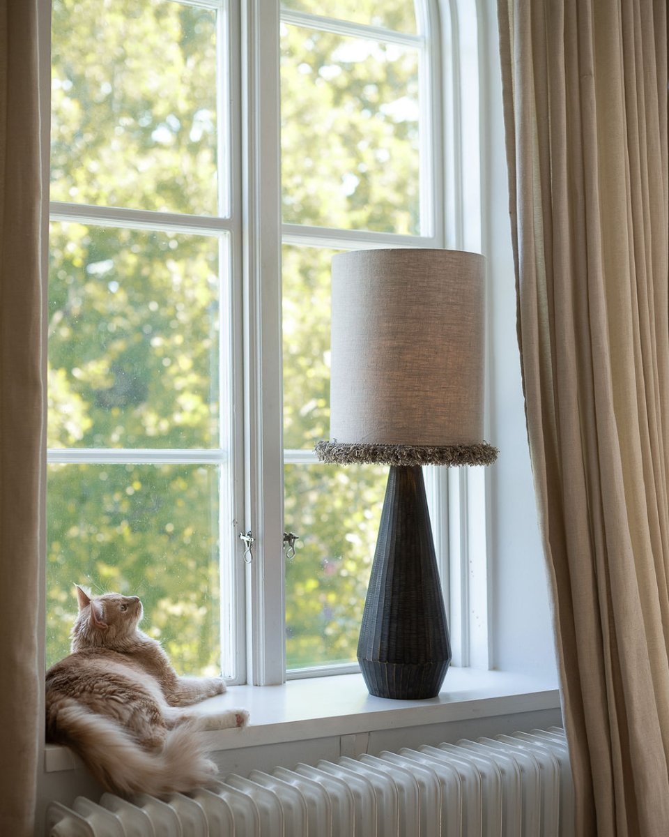 Lampskärm Cylinder Frans Ø30 Natur från Alde & Lind - Kanterna &auml;r omsorgsfullt invikta och l&auml;ngs nederkanten l&ouml;per en dekorativ, kraftig sn&ouml;rmakerifranskant som ger lampsk&auml;rmen en elegant och exklusiv detalj.
