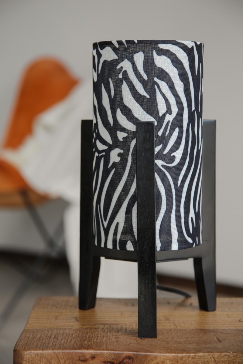 Eruca 34cm Zebra bordslampa från Markslöjd - Lampfoten i svart tr&auml; kombineras med en cylinderformad textilsk&auml;rm i svartvitt zebram&ouml;nster, vilket ger lampan en grafisk och uttrycksfull karakt&auml;r.
