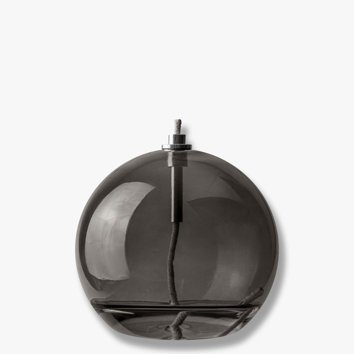 Oljelampa Aura Mellan Rökfärgad från Mette Ditmer - Dess eleganta design och r&ouml;kf&auml;rgade glas sprider ett mjukt, varmt ljus som ger en lugn och mysig k&auml;nsla.