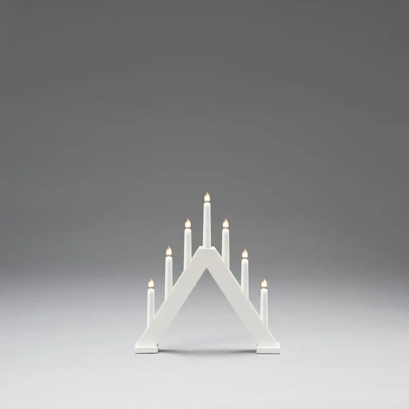 Elljusstake 7ljus Vit från Konstsmide - Den klassiska pyramidformen kombineras med en minimalistisk design, vilket g&ouml;r den till en perfekt inredningsdetalj i b&aring;de traditionella och moderna hem.