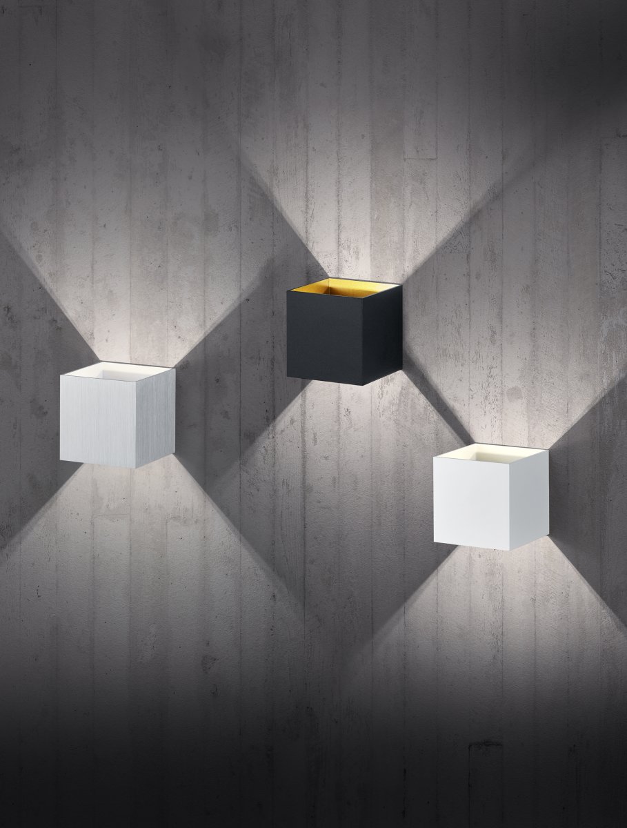 Louis 10cm Svart vägglampa från Trio Lighting - Dess dubbla ljusuttag upp&aring;t och ned&aring;t skapar en elegant ljusk&auml;gla som ger rummet en harmonisk atmosf&auml;r.
