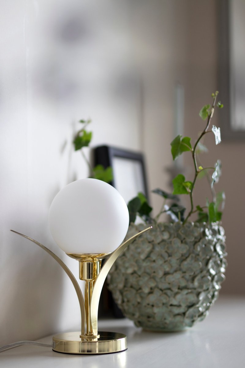 Savoy 26cm Mässing bordslampa från Globen Lighting - Bordslampa med tre f&ouml;rm&auml;ssigade b&ouml;jande blad som i mitten h&aring;ller ett opalf&auml;rgad runt glas.