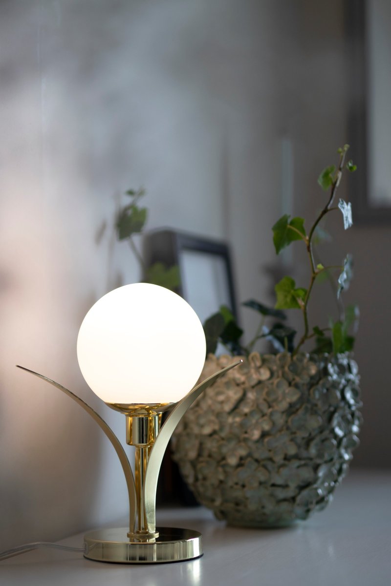 Savoy 26cm Mässing bordslampa från Globen Lighting - Bordslampa med tre f&ouml;rm&auml;ssigade b&ouml;jande blad som i mitten h&aring;ller ett opalf&auml;rgad runt glas.