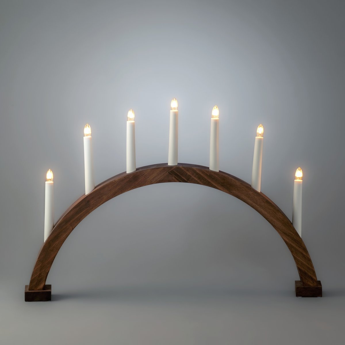 Båge 7ljus Brun från Konstsmide - B&aring;gen &auml;r tillverkad i tr&auml; med brunbetsad finish som ger ett naturligt och tidl&ouml;st uttryck.