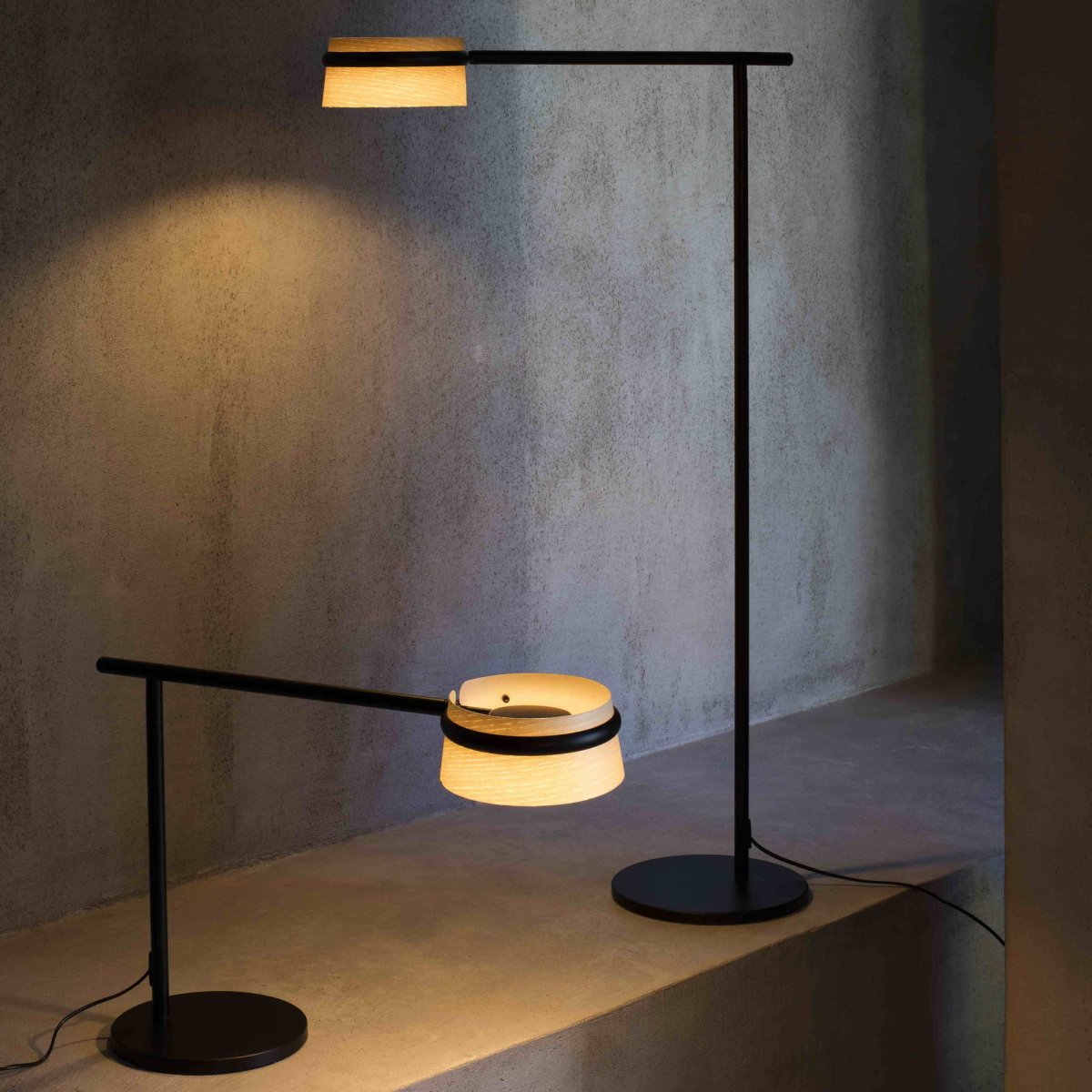 Loop Trä golvlampa från Faro Barcelona - Golvlampan k&auml;nnetecknas av sin r&auml;ta vinkel, en rund metallbas och ett elegant armf&auml;ste som omsluter en asktr&auml;sk&auml;rm.