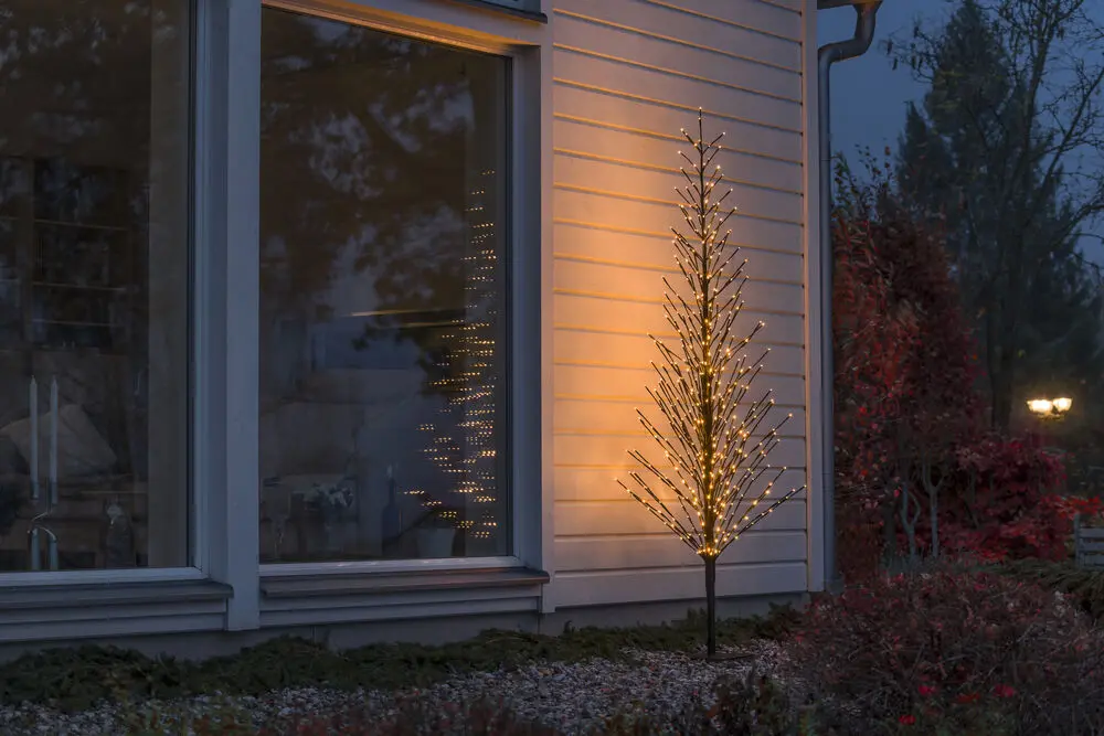 Svart träd 210cm Svart från Konstsmide - Ett elegant svart dekortr&auml;d som lyser upp vintern med 504 varma amberf&auml;rgade LED-ljus i steady- och firefly-effekt.