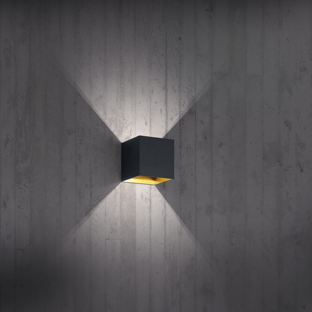 Louis 10cm Svart vägglampa från Trio Lighting - Dess dubbla ljusuttag upp&aring;t och ned&aring;t skapar en elegant ljusk&auml;gla som ger rummet en harmonisk atmosf&auml;r.