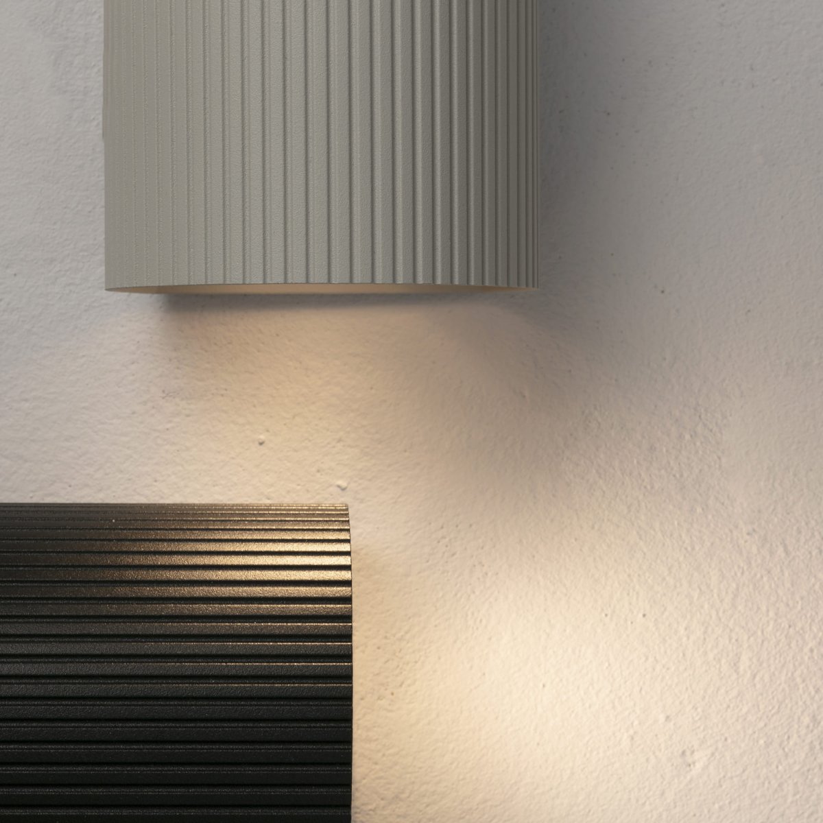 Sole 10cm Vit räfflad vägglampa från Faro Barcelona - Finns i tv&aring; storlekar och kan avge ljus i en eller tv&aring; riktningar &ndash; perfekt f&ouml;r hallar, trapphus och mindre utrymmen.