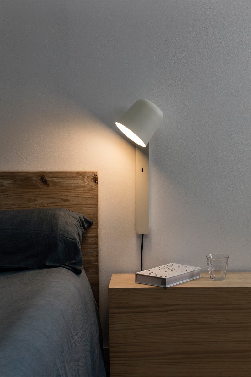 Tila 46cm Vit läslampa från Faro Barcelona - Den vita st&aring;lstrukturen i nordisk stil rymmer inte bara en fullt justerbar ljusk&auml;lla, utan fungerar &auml;ven som praktisk hylla f&ouml;r en bok eller tidskrift.