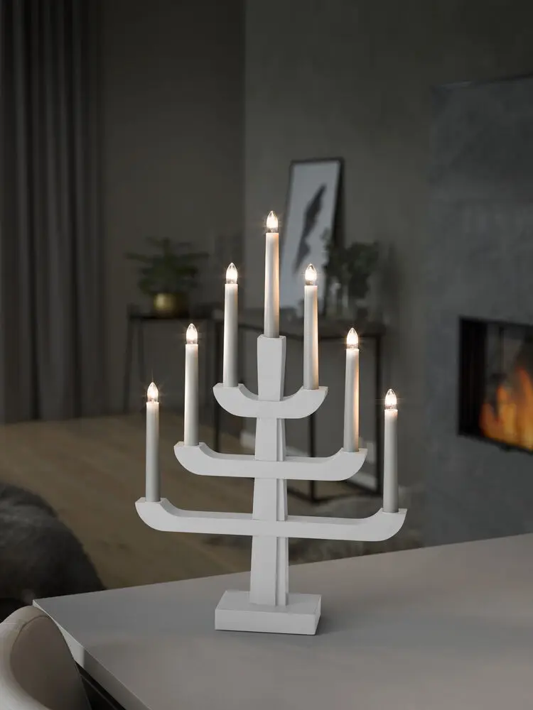Elljusstake 7ljus Vit från Konstsmide - Med sina tre stilfulla niv&aring;er och sju varmvita ljus kombinerar den klassisk charm med nutida formgivning.