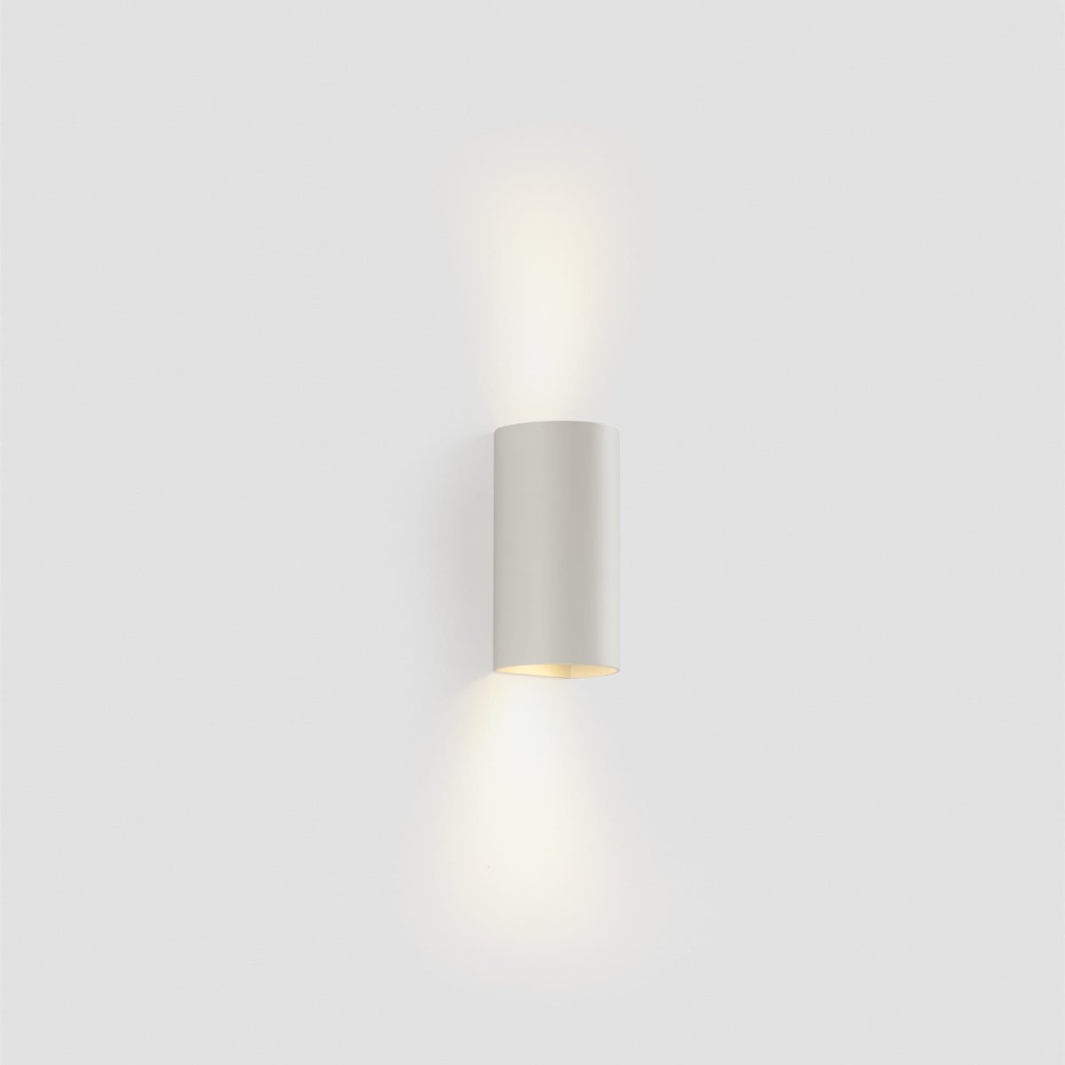 Sole 15cm Vit vägglampa från Faro Barcelona - Finns i tv&aring; storlekar och kan lysa i en eller tv&aring; riktningar, vilket g&ouml;r den idealisk f&ouml;r hallar och mindre utrymmen.