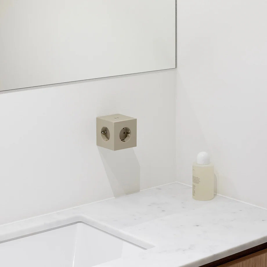 Square 2 Socket extender with 30W Dual USBC Sand från Avolt - Uttagsf&ouml;rl&auml;ngare fr&aring;n Avolt med en stilren design med en kub i &aring;tervunnen plast och en magnetplatta i botten f&ouml;r att kunna h&auml;ngas upp p&aring; v&auml;ggen.