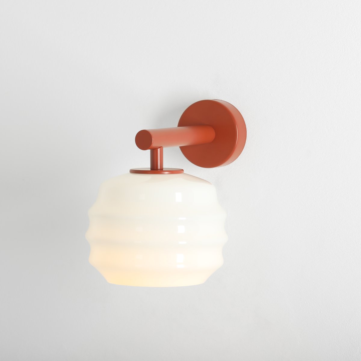 Puff 23cm Terrakotta vägglampa från Artera - Den dekorativa sk&auml;rmen i vitt opalglas har en v&aring;gig form som ger lampan ett lekfullt och elegant uttryck.