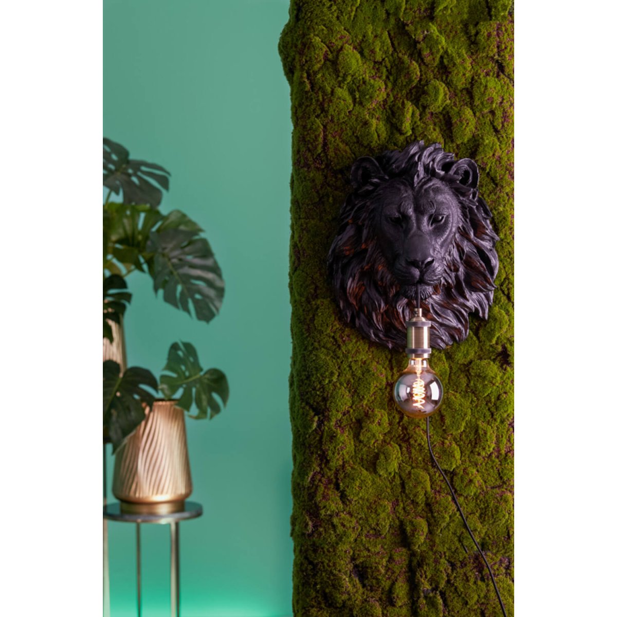 Lion 40cm Svart vägglampa från Light & Living - Ljusk&auml;llan h&auml;nger elegant fr&aring;n lejonets mun med en dekorativ m&auml;ssingssockel, vilket skapar en dj&auml;rv och st&auml;mningsfull atmosf&auml;r.