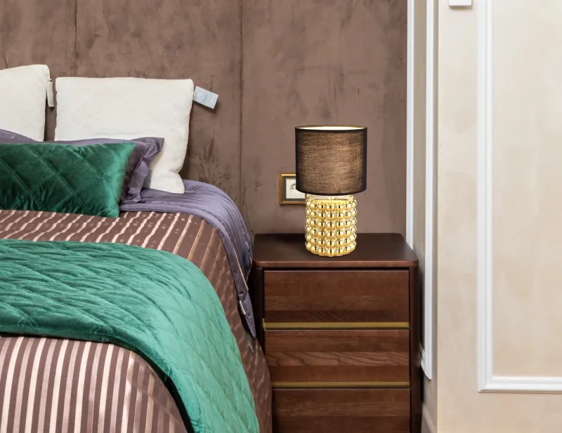 Valentino 33cm Guld bordslampa från Globo Lighting - P&aring; en cylinderformad fot i guldf&auml;rgad keramik vilar en stilren, svart textilsk&auml;rm.