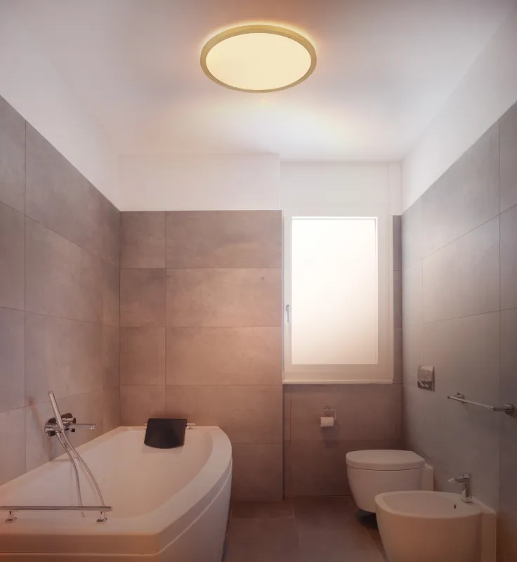 Sapana Ø30 Mässing badrumslampa från Globo Lighting - Lampan &auml;r tillverkad av matt m&auml;ssingsf&auml;rgad och vit plast, vilket ger ett mjukt och bl&auml;ndfritt ljus.