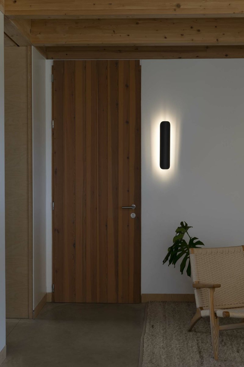 Novo 50cm Svart vägglampa från Faro Barcelona - Lampan &auml;r tillverkad i metall och kan monteras b&aring;de vertikalt och horisontellt, vilket g&ouml;r den flexibel f&ouml;r olika rum och behov.