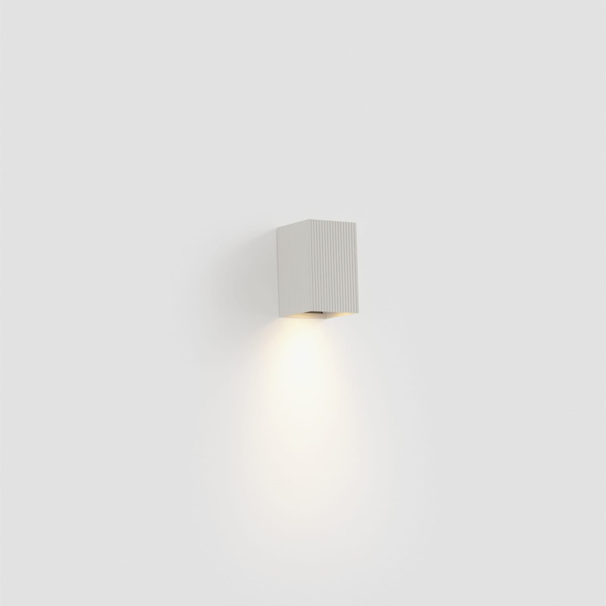 Lune 10cm Vit räfflad vägglampa från Faro Barcelona - Den strukturerade finishen tillf&ouml;r en subtil elegans och skapar en stilfull k&auml;nsla i rummet.