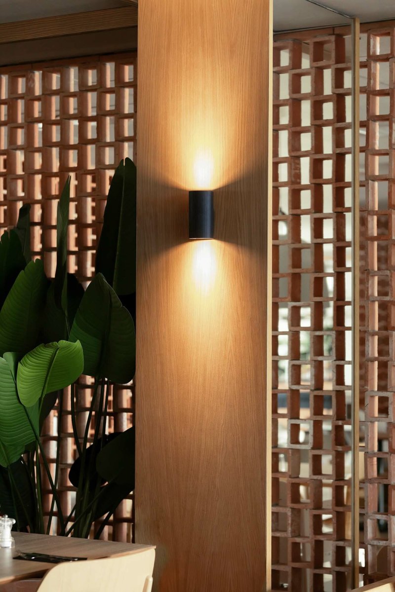 Sole 15cm Svart räfflad vägglampa från Faro Barcelona - Den finns i tv&aring; storlekar och kan avge ljus i en eller tv&aring; riktningar, vilket g&ouml;r den idealisk f&ouml;r hallar och mindre utrymmen.