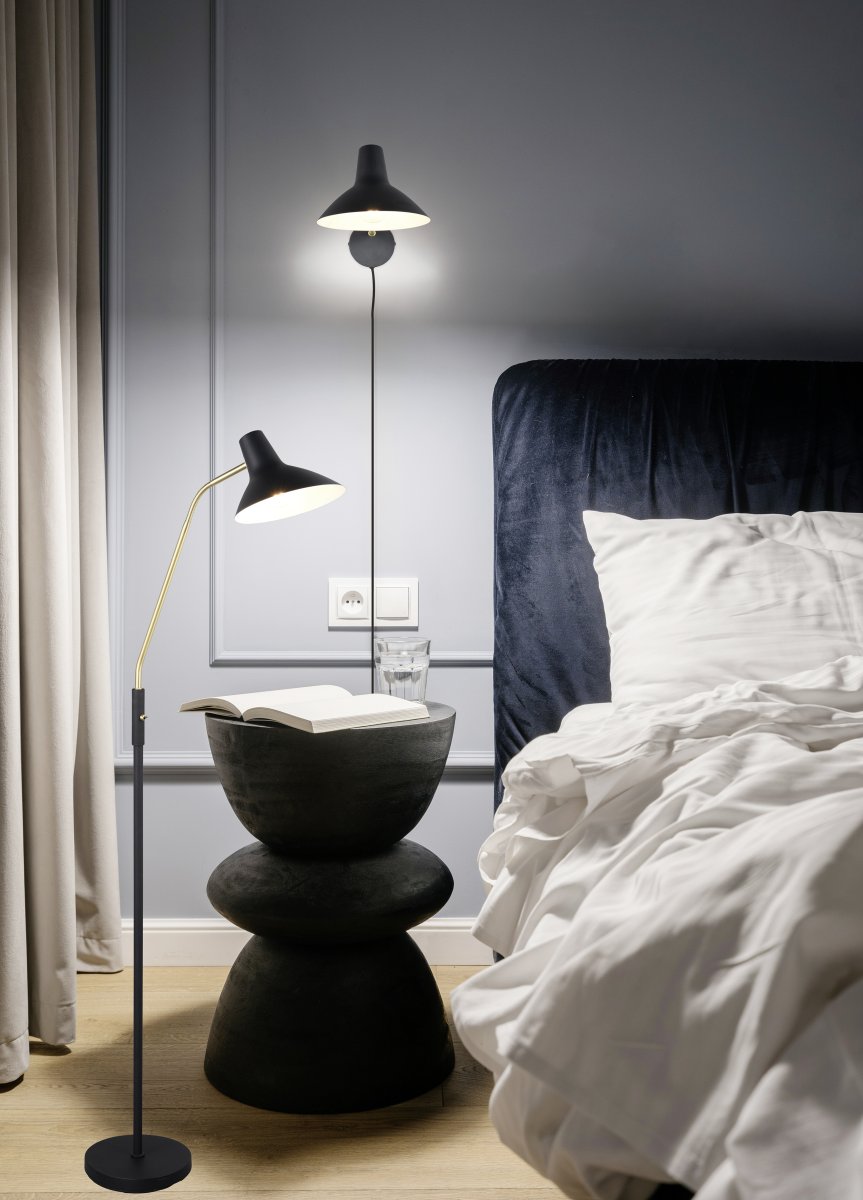 Traveller Svart golvlampa från Trio Lighting - Den svarta f&auml;rgs&auml;ttningen och ljusarmen i matt m&auml;ssing ger en sofistikerad touch, medan den minimalistiska designen sm&auml;lter in i olika inredningsstilar.