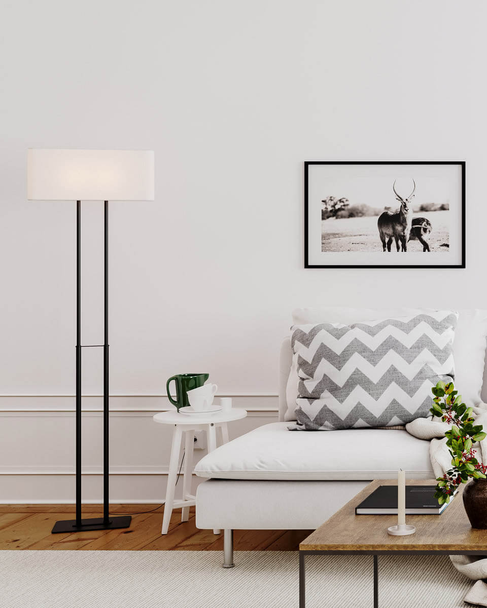 Luton Svart golvlampa från By Rydéns - Foten i svart metall med det l&aring;nga stativet gifter sig utm&auml;rkt med den rektangul&auml;ra linnesk&auml;rmen i vitt.