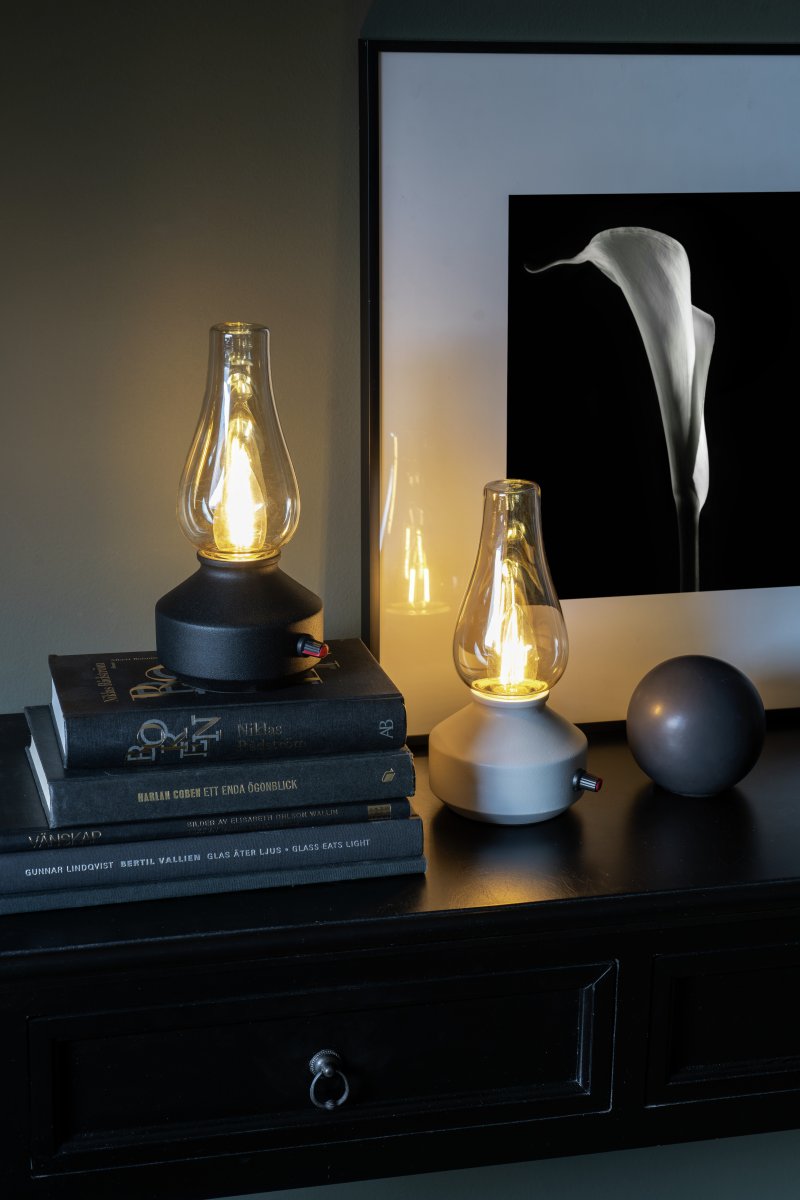 Laddbar bordslampa 25cm Vit portabel från Konstsmide - Lampan &auml;r tillverkad av metall och glas med en vit lampfot och en praktisk dimmer som g&ouml;r det enkelt att justera det varmvita, st&auml;mningsfulla skenet.