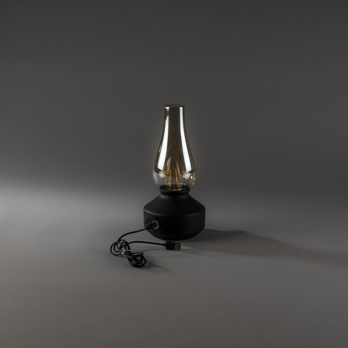Laddbar bordslampa 25cm Svart portabel från Konstsmide - Lampan &auml;r tillverkad av metall och glas med en svart lampfot och en praktisk dimmer som g&ouml;r det enkelt att justera det varmvita, st&auml;mningsfulla skenet.