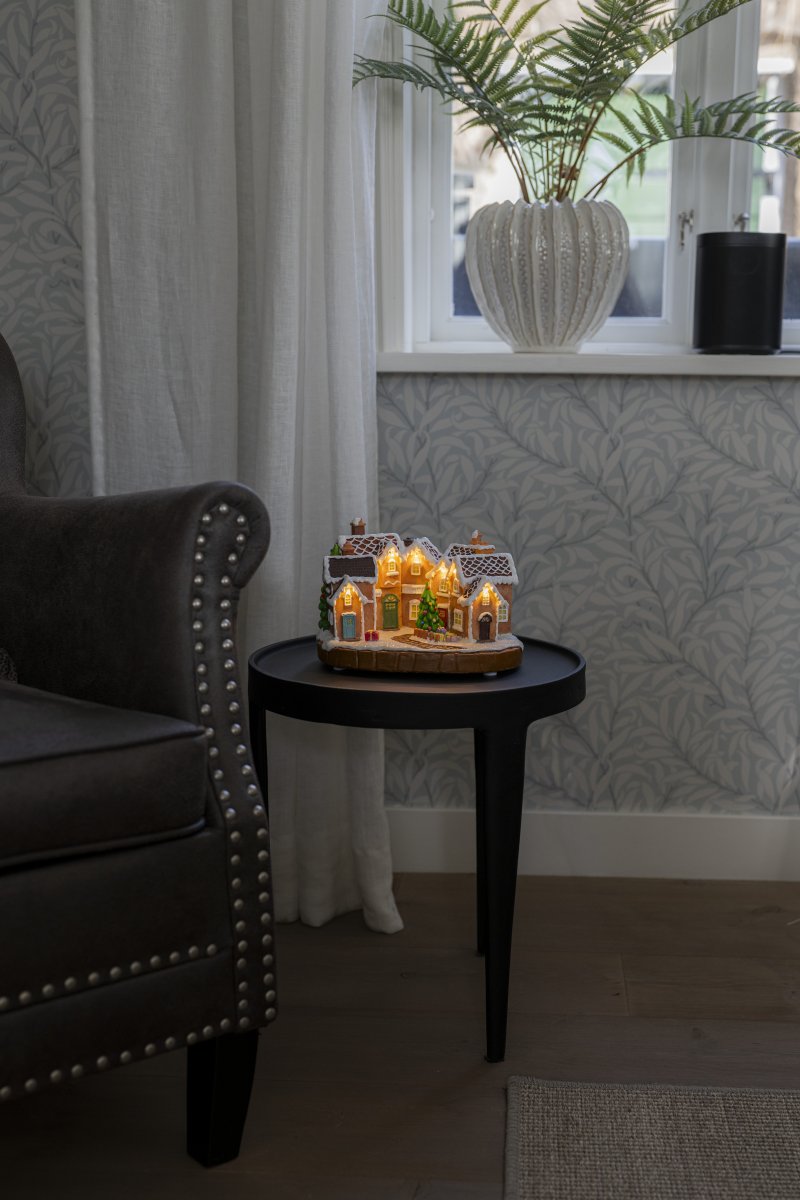 Pepparkaksby 17cm Brun från Konstsmide - De sn&ouml;t&auml;ckta taken, f&auml;rgglada d&ouml;rrarna och den dekorerade granen i mitten ger k&auml;nslan av en sagolik julmilj&ouml;.