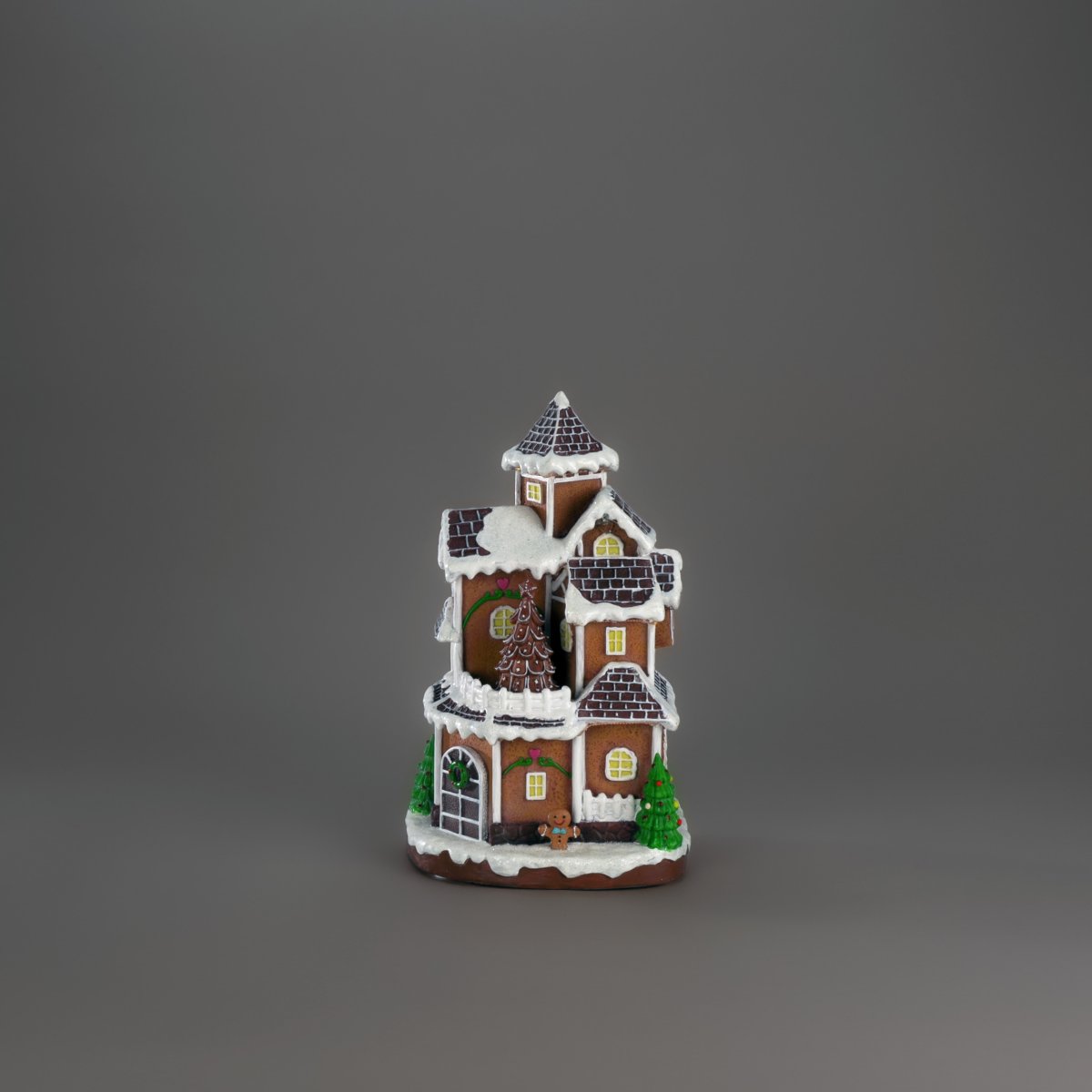 Pepparkaksby 30cm Brun från Konstsmide - Det detaljrika huset med sn&ouml;t&auml;ckta tak, lysande f&ouml;nster och dekorerad gran sprider ett varmt och inbjudande sken i rummet.