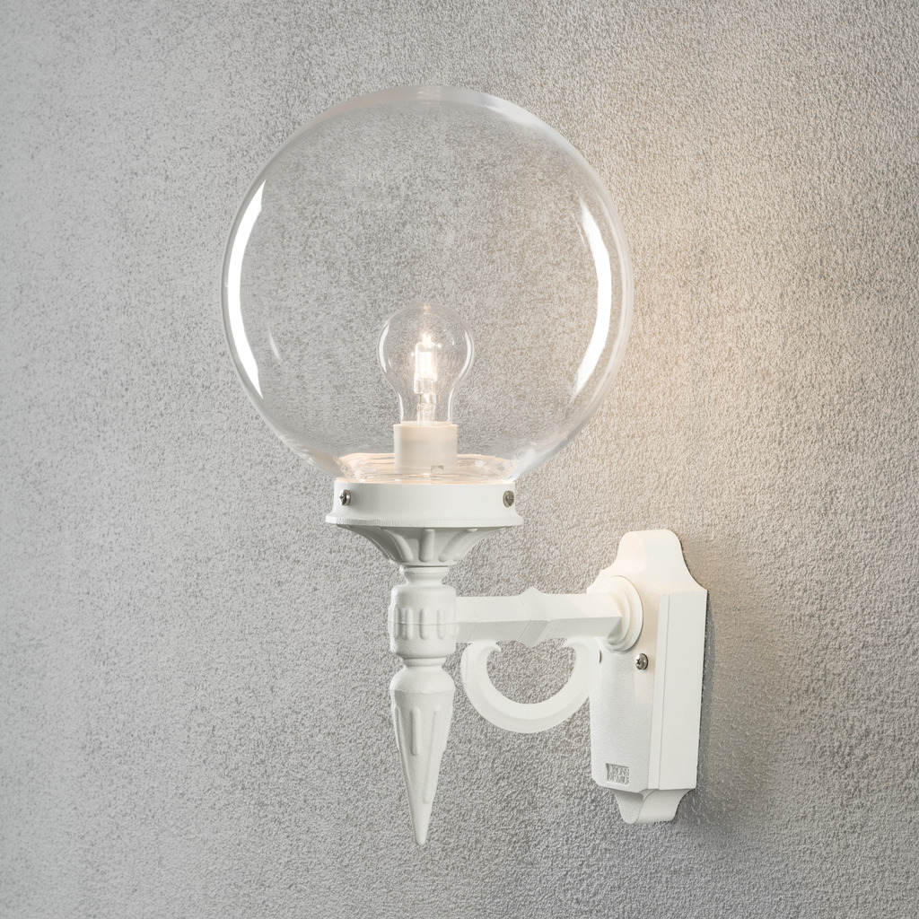 Orion Vit utelampa från Konstsmide - Med sina dekorativa detaljer och tidl&ouml;sa stil blir denna v&auml;gglampa en elegant detalj som lyfter din fasad och skapar en inbjudande atmosf&auml;r.